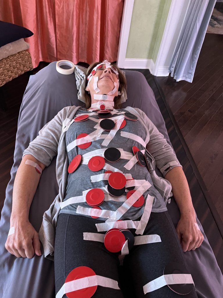 image of a woman lying down with magnets taped on her