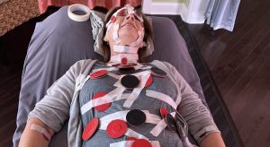 image of a woman lying down with magnets taped on her