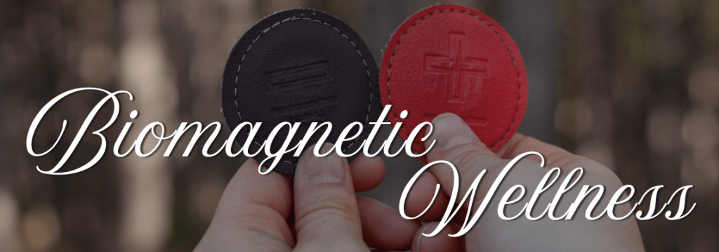 biomagnetic wellness text over an image of magnets held by hands in the forrest